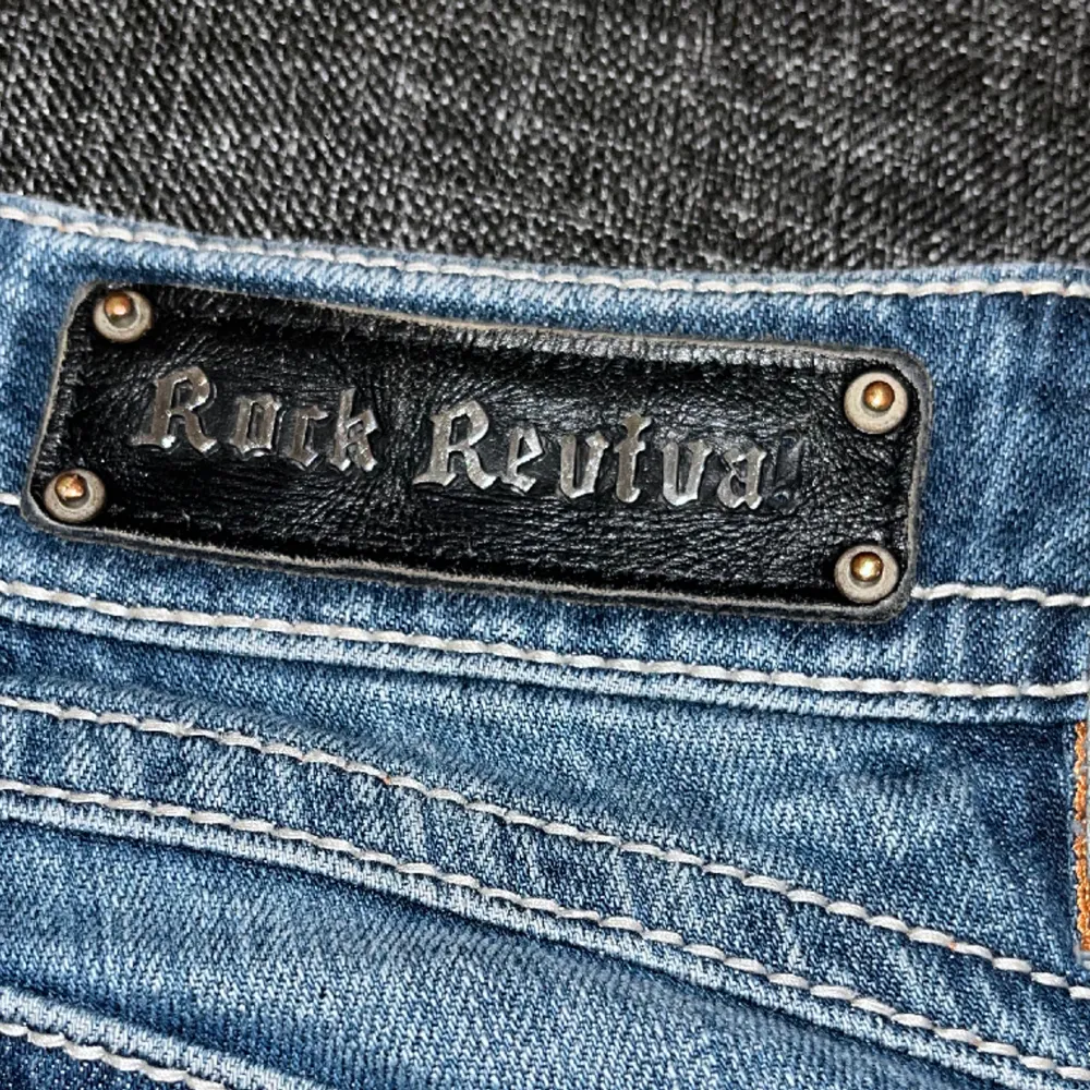 Lågmidjade jeans från rock Revival.  Fint skick men som ni ser på bild 3 så har den tappat en bokstav men inget man tänker på. Bootcut Strl W28. Jeans & Byxor.