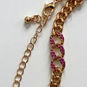 Vackert guldfärgat armband med rosa rhinestones  Okänt material  23 cm