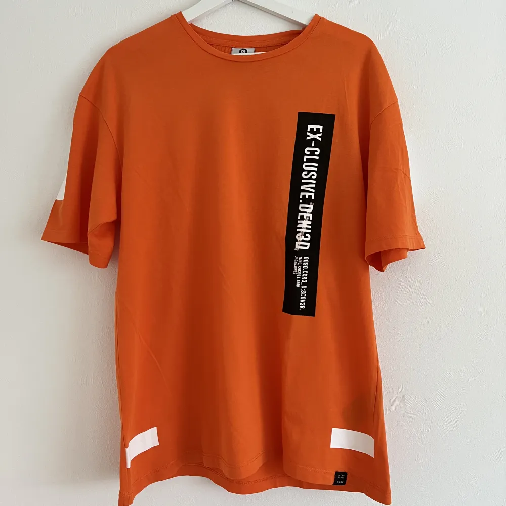 Orange t-shirt med tryck från Jack and Jones. Färgen kan vara lite ljusare än vad som uppfattas på bilderna. . T-shirts.