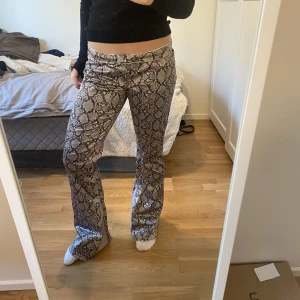 Ormmönstrade byxor - NYPRIS 700kr Säljer ascoola lågmidjade utsvänga byxor med ormmönster och coola detaljer i tyget