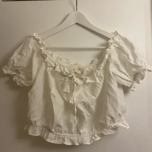 Topp - Vit croppaf topp med volanger, endast använd ett fåtal gånger. Storlek 44 men den är liten i storleken så passar en M/L.