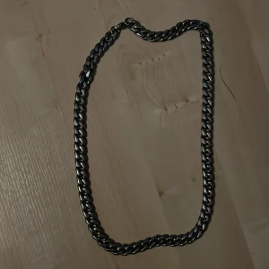 Halsband  - En  Pansarlänk i rostfritt stål som är 1 cm bred. Halsbandet har knappt blivit använd därför ja säljer det.