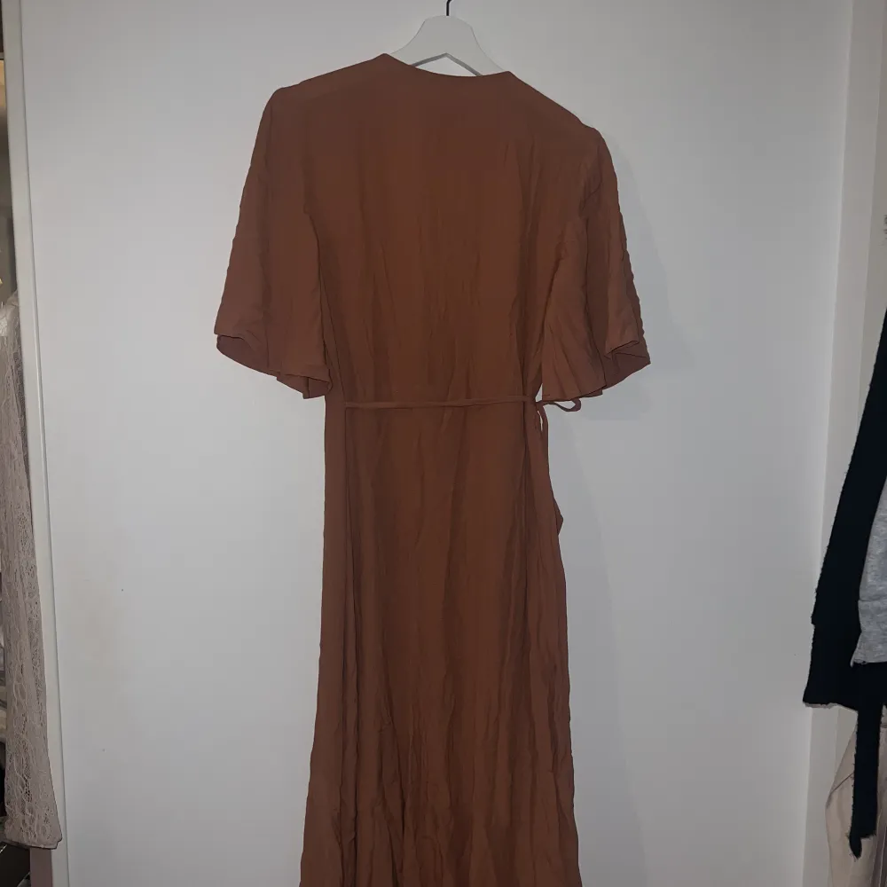 Fin klänning från Carin Wester, klänningen är omlott och är i en ljus orange/korall färg (ljusare än på bilden) den är i storlek 36 men eftersom den är omlott så kan man välja lite hur den ska sitta, extremt skönt tunt material till sommaren . Klänningar.