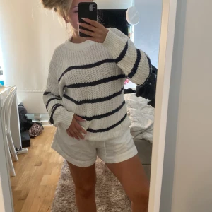 Stickad tröja - En stickad tröja som är vit med blåa ränder på. Super skön 