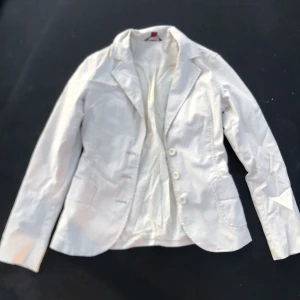 Vit kavaj jacka - Den formar sig fint efter kroppen och är oanvänd och har inga fläckar eller hål. Den har två fickor där fram. Det finns två extra knappar om nån råkar lossna