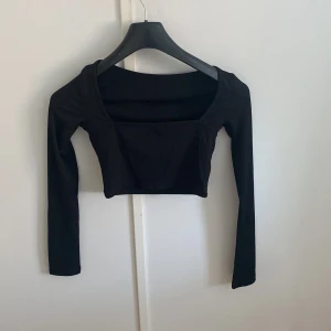 Långärmad crop top med fyrkantig hals - En square neck långärmad crop top. Oanvänd