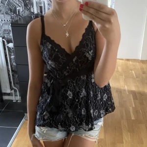 Mönstrig blus - Jätte söt svart mönstrig blus med rosett. Pris plus frakt. 