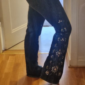 Bootcut jeans - Jeans med påsydda psljetter och blommor längs ned! Suuupersnygga bara för små för mig. Från Beyond retro köpta för 600 med lappen kvar. Nästan helt oanvända