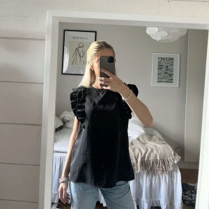 Svart Blus Med Volang - jätte fin svart blus med volang på ärmarna som passar till allt😍 Aldrig använd, så som ny. säljer pga att det är för stor. Storlek xs💞💞 