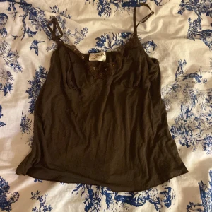 Brunt y2k linne - Jätte gulligt brunt linne med lite spets och paljetter på, typ 2 paljetter saknas men annars i bra skick!🌥️ passar nog storlek s och m. Säljer pga att de är för stor för mig😊 