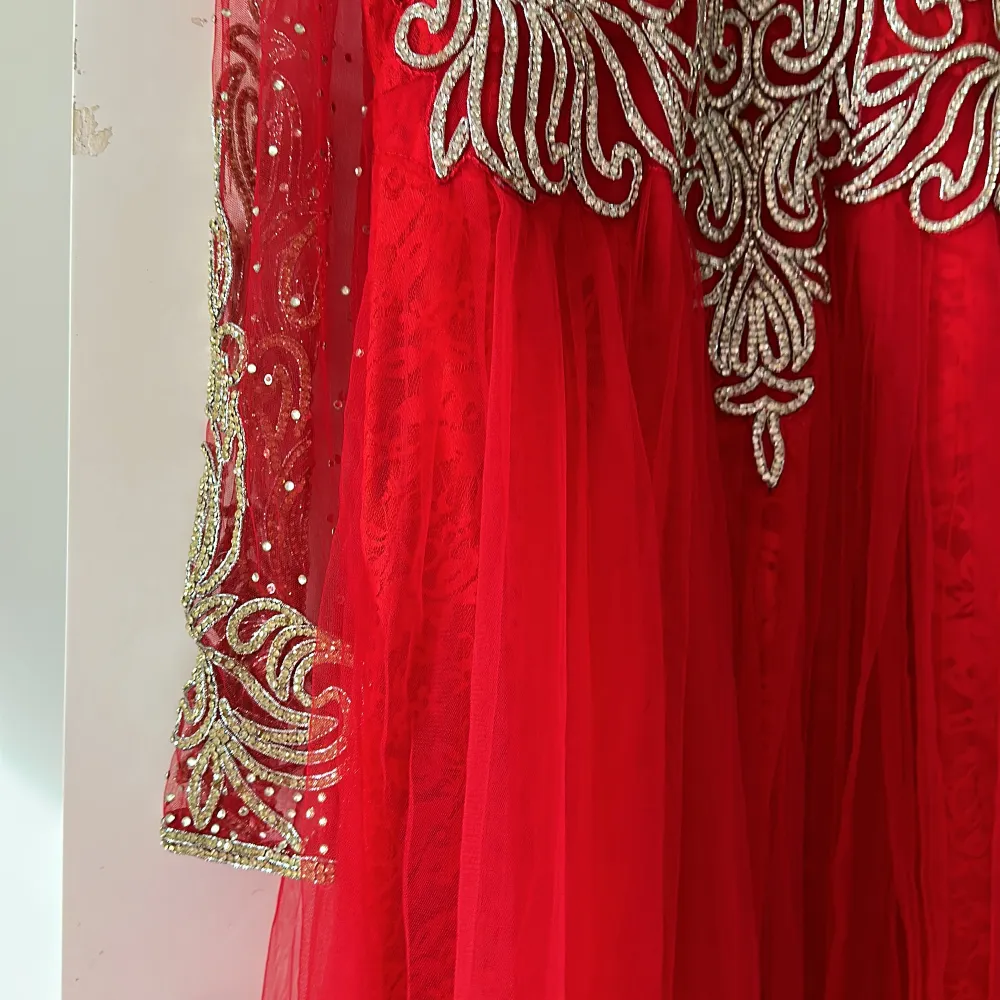 En röd lång klänning, utsmyckad med massa vita glittriga kristaller.  . Klänningar.