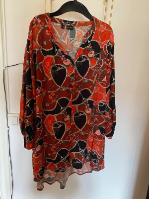 Blusar - Blommig blusskjorta. Lite använd, mycket skön. Blommig gul blus. Tunn och sval. Gott skick.  Orange blus med satin på framsidan och stretchigt bommulstyg på baksidan. 