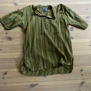 En grön randig tröja  - Man kan säga att tröjan är en slags hippie tröja. Den har två fläckar 