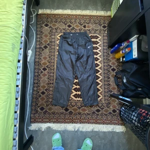 Nike byxor - Ett par tvär feta nike byxor i storlek Large. Har dragkedja vid smalbenet som ändrar lite passform till vidare benöppning. Har feta nike ticks på båda sidorna som är gömda om man drar upp zippen.  Mått finns i kommentarerna