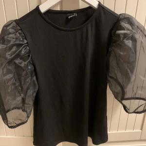 Topp med puffärmar - Helt oanvänd topp med mesh puffärmar, i strl M 