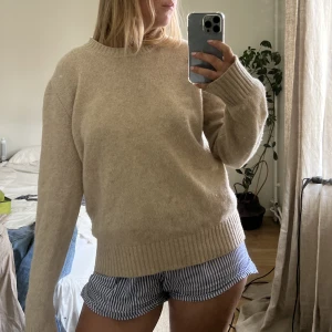 Stickad tröja  - Superfin beige stickad tröja från benetton. 100% ull. Så fin nu på sommaren över en kjol eller klänning