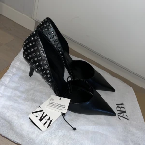 Klackskor med nitar - Riktigt snygga klackskor med 6 cm klack! Aldrig använda bara provade då dom är för stora för mig. Kommer med en Zara dustbag! 