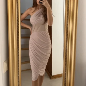 Gräddvit asymmetrisk klänning  - Klänning från ASOS. Använd endast en gång för en förlovning. Känningen är väldigt bekväm och superfin. 