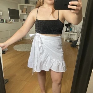 Kjol - Vit kjol som man knyter och stänger med en knapp. Från NellyTrend i storlek 36. Säljer då jag tycker den är för lång på mig som endast är 150 cm. Använd en gång.