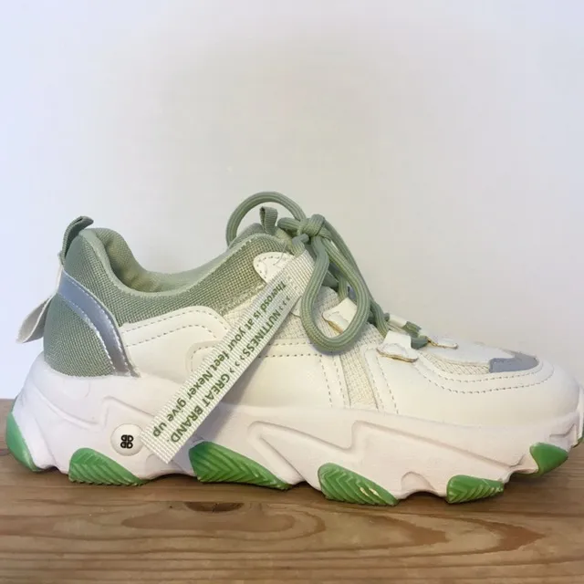Supersnygga trendiga vita sneakers med gröna detaljer (mintgrönt foder och snören, grön sula). Strl 38. Endast använda en gång, riktigt bra skick :). Skor.