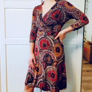 Stockholmsfabriken  - Omlottklänning i underbar stretch, från Stockholmsfabriken. Mycket gott skick och mycket bra kvalitet. Är väldigt formbar - kan bäras av strl 36, 38, 40. Både smal och kurvig. Upp till F-kupa.