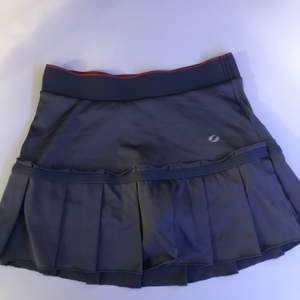En supersöt tennis kjol i grått med rosa orangea shorts under. Inte använd så mycket så den är i fint skick. Stl.XS/S