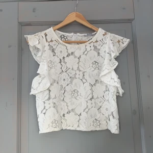 Zara linne - Så gullig spetstopp från Zara! Typ som en väst/ linne med volanger runt ärmarna, lite boxig och croppad passform. Storlek M men skulle tro att den passar nån som är XS eller S bättre, jag själv har oftast S i tröjor.