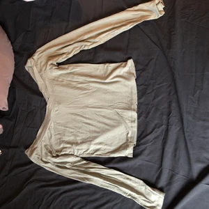 Långärmad open shoulder tröja storlek S - En off the shoulder tröja med långa ärmar. Tröjan har en grön färg