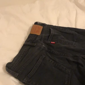 LEVI’S Jeans strl. 27 - Säljer dessa svarta Levi’s, strl. 27. Jag är 165 lång och de går ner på anklarna på mig. Färgen är inte kålsvart, lite sliten svart som syns tydligt på första bilden. Köpta för ett par år sen, använda ganska sparsamt! Bra skick!