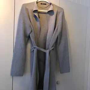 stickad kappa med skärp i grått