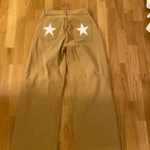 Jeans - Snygga beiga jeans med vita stjärnor där bak. Använder ej.