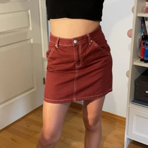 Vinröd jeanskjol - Divided vinröd kjol med vita sömmar. Skriv om du har frågor eller funderingar. Fint skick!