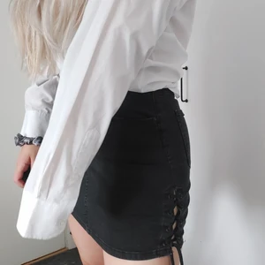 Kjol med snöre - Svart kjol köpt på gina tricot. Storlek 36. Har snörning på båda sidorna av utsidan på benen. Rätt så stretchigt material.