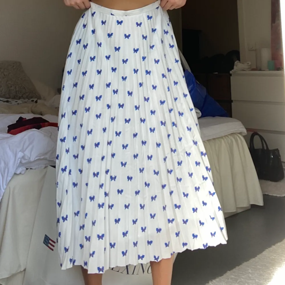En vit kjol med blåa söta fjärilar på. Köparen står för frakt . Kjolar.