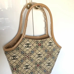 Chanel väska - Supersnygg väska med chaneltryck, ej äkta!! Väskan är sliten på remarna och fodret, men har mycket kvar att ge!! 