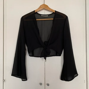 Svart topp - Svart genomskinlig topp som man knyter ihop. Hittad på secondhand. Tyvärr en liten färgfläck på längst ner på ärmen men inget man tänker på. Står ej storlek men skulle gissa på M 🌻