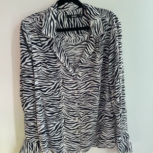 Zebra tryck skjorta med V-ring - Säljer denna häftiga zebra-tryck blus/skjorta då den ej kommit till användning. Från BIKBOK och endast använd ett fåtal gånger 💖 jättesnygg V-ring i kragen & generellt bra passform