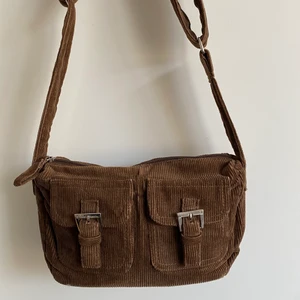 Handväska manchester - Supersöt brun handväska i Manchester! Köpt här på Plick. Justerbart band så går att använda som på bilden och diagonalt!