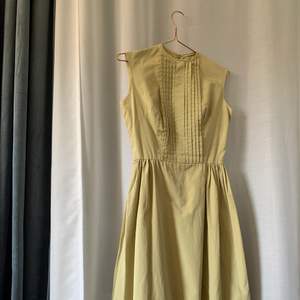 Skräddarsydd klänning med vackra detaljer i ljusgrönt. 50-tal. Fint skick.  