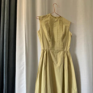 Vintageklänning ca 50-tal - Skräddarsydd klänning med vackra detaljer i ljusgrönt. 50-tal. Fint skick.  