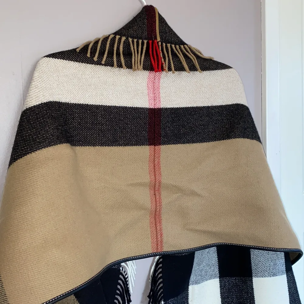 Äkta burberry: ”check wool cashmere jacquard cape”. Använd 1 gång, i gott skick. 180 x 60cm. 90% ull, 10% cashmere, trim i läder. Inköpsvärde: 11 800kr. Tröjor & Koftor.