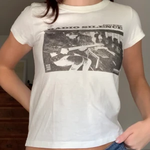 T-shirt från Brandy Melville - Helt ny vit t-shirt med tryck från Brandy Melville, säljer då jag tror att jag inte kommer få så mycket användning för den! Typ one size men passar mig som brukar ha XS/S 🤍
