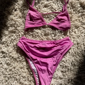 Lila/rosa populär bikini från pretty little thing - Highwaisted underdel och överdel som är lätt att dra på från pretty little thing. Använt 4 ggr bara. För liten för mig nu. Överdel S och underdel M. Rosa/lila färg. Super bekväm 