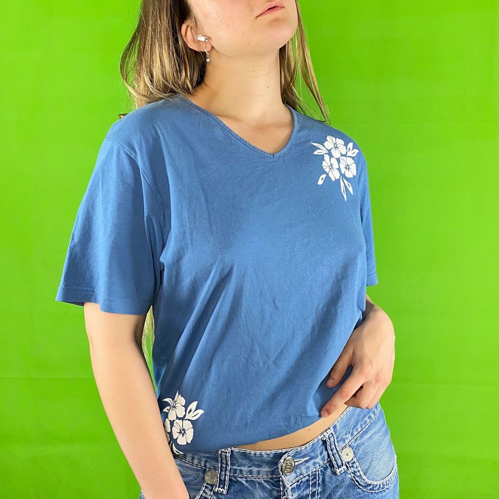 Hibiscus t-shirt i fint skick, somrig coconut girl t-shirt! Slits på båda sidorna. En liten. Se sista bilden för några svaga ränder. Inget märke eller material finns kvar. Modellen använder vanligtvis storlek S och är 169cm för referens. Spårbar frakt på 66kr är inräknad i priset. Axel till axel 46cm. Axel och ner 70cm. Byst bredd 53.5cm. Arm längd 22.5cm.. T-shirts.