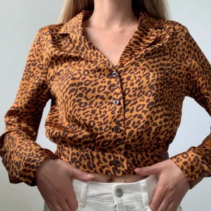 Skjorta/Blus i leopard  - En supercool kort skjorta/blus i leopardmönster i satinaktigt material (glansigt). Kommer från Prettylittlething och är i strl 36. Använd endast ett fåtal ggr så är i perfekt skick! FRAKT tillkommer från 66kr. 