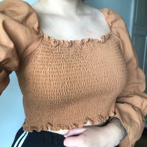 Kort topp med veckade detaljer  - Brun veckad topp med krås och remsa med en smal passform. Väldigt vacker till sommaren men funkar också under övriga årstider. Toppen är från SHEIN!