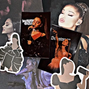 Ariana Grande Tour Set - Inkluderar = 2 tour collection cards, 3 st 10cm x 15cm Ariana bilder & random svarta Ariana klistermärken                            I lager = 2 i lager                                                                         Om = Ett jätte fint Ariana Grande set som du kan köpa i present t någon eller bara till dig själv 