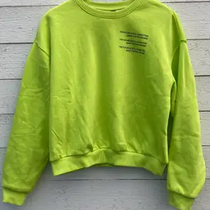 Fin sweatshirt från Divided H&M. Neongrön med svart text. 