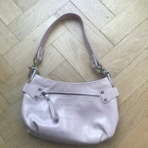 Longchamp väska - Superfin glansig ljusrosa väska i äkta läder från longchamp, säljer då den inte kommer till användning längre. Finns tre fack på insidan. Jättebra skick, som ny. 28x19 cm.    