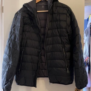 Dunjacka Svart - En svart dunjacka från H&M i storlek M. Den finns ett litet igen sytt hål på jackan. 